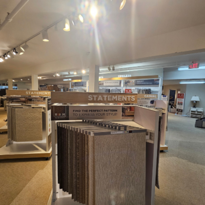 Barlett's Home Interiors in Charlevoix, MI, showcasing carpet and tile displays under 'STATEMENTS' signage.